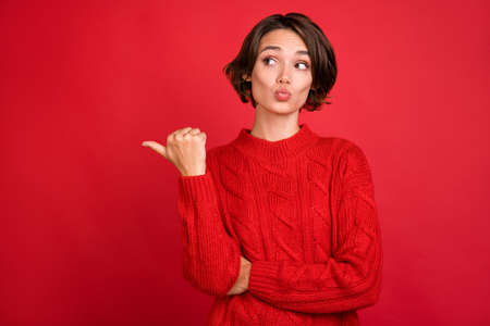 Photo portrait young woman sending air kiss pointing thumb copyspace isolated vibrant red color backgroundの写真素材