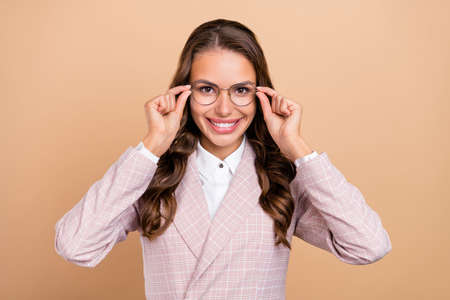 Portrait of charming cheerful lady arms touch glasses beaming smile look camera isolated on beige color backgroundの写真素材