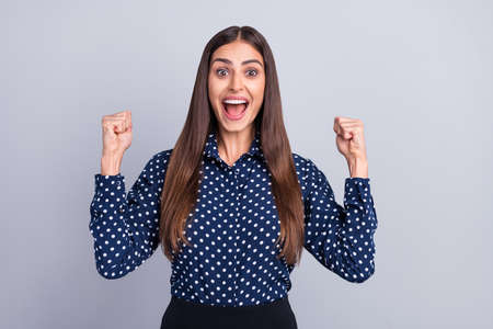 Portrait of attractive cheerful businesswoman assistant celebrating having fun isolated over grey color backgroundの写真素材
