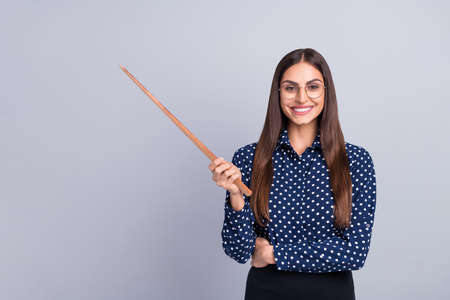 Portrait of attractive cheery businesswoman pointing copy empty blank space isolated over grey color backgroundの写真素材