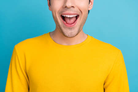 Cropped photo of young excited man happy positive smile amazed surprised news isolated over blue color backgroundの写真素材