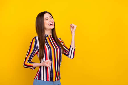 Profile side photo of young attractive woman happy positive smile rejoice victory success isolated over yellow color backgroundの写真素材