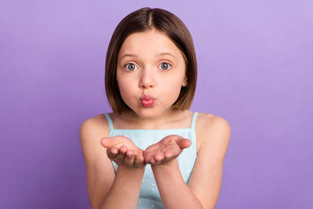 Photo of charming young lovely little girl send air kiss you hands cheerful lady isolated on purple color backgroundの写真素材