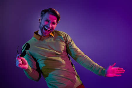 Photo of funny funky positive happy man dance hold hands glasses good mood isolated on neon backgroundの写真素材