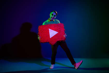 Full length body size photo man in sunglass keeping social media network icon isolated on dark blue color backgroundの写真素材