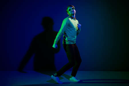 Full length body size photo guy wearing sunglass enjoying party in night club isolated dark blue color backgroundの写真素材