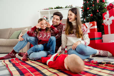 Full length photo of happy cheerful family xmas good mood play game miracle tradition indoors inside houseの写真素材