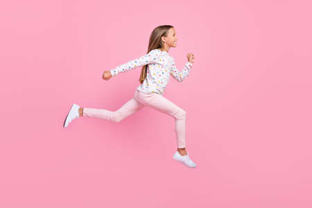 Profile photo of sportive small lady jump run wear dotted pajama pants footwear isolated pink color backgroundの写真素材