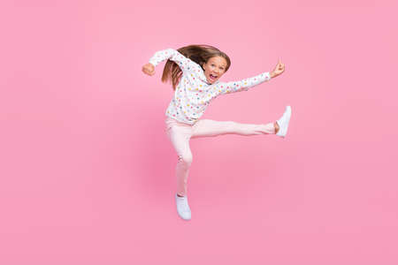 Photo of crazy karate little kid lady jump kick leg wear dotted pajama pants shoes isolated pink color backgroundの写真素材