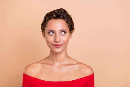 Photo of dreamy pretty minded young woman look empty space wonder idea isolated on pastel beige color backgroundの写真素材