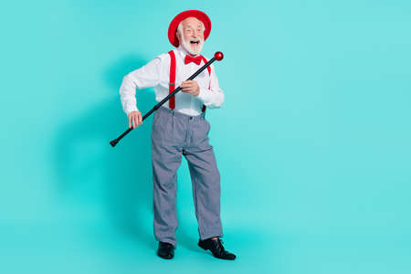 Full length body size view of attractive cheerful mister having fun using cane like mic isolated over bright teal turquoise color backgroundの写真素材
