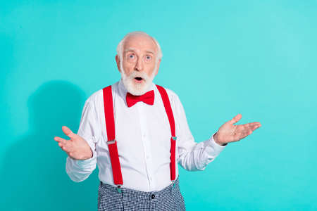 Portrait of attractive amazed grey-haired mister looking up copy space waiting isolated over bright teal turquoise color backgroundの写真素材