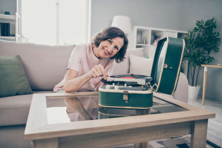 Photo of aged brunette funky lady listen music wear pink t-shirt at home aloneの写真素材