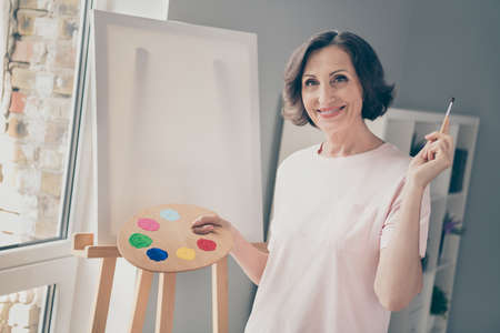 Photo of mature paint brunette lady wear pink t-shirt at home aloneの写真素材