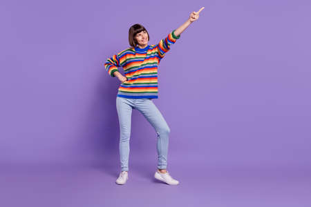 Photo of promoter lady direct finger empty space wear striped pullover jeans shoes isolated violet...