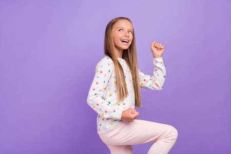Photo of dreamy inspired little lady look empty space attain goal wear dotted pajama isolated purple...