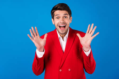 Photo of young man happy positive smile amazed shocked reaction sale information isolated over blue...