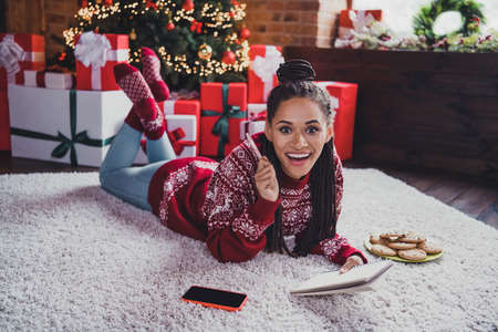 Photo of excited genius lady lay floor write dream notes have idea wear pullover in decorated home...