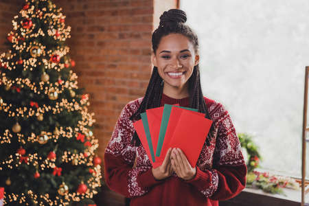 Photo of cheerful lady hold fan envelop prepare send mail post wear pullover in decorated home...