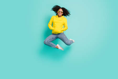 Full length body size photo woman jumping up wearing casual clothes isolated bright teal color...