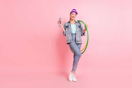 Full size photo of sportive blond millennial lady stand do excercise wear jeans jacket visor isolated on pink color backgroundの写真素材
