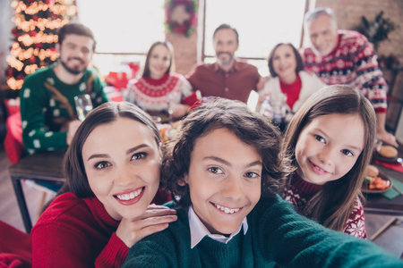 Self-portrait of attractive big full adorable cheerful family meeting homemade lunch party at home indoorsの写真素材