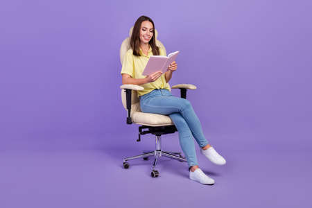 Full body photo of cute young brunette lady read book sit on armchair wear top jeans footwear...