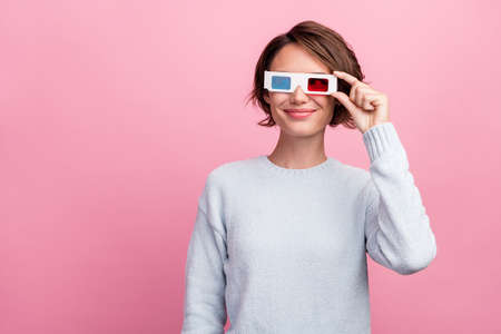 Photo of dreamy positive happy young woman wear 3d glasses look empty space watch isolated on pink color backgroundの写真素材