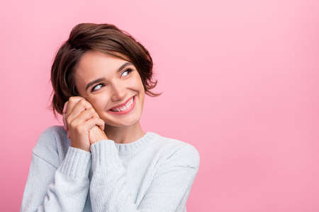 Photo of dreamy inspired cute pretty lady hands cheeks look empty space wear blue sweater isolated...