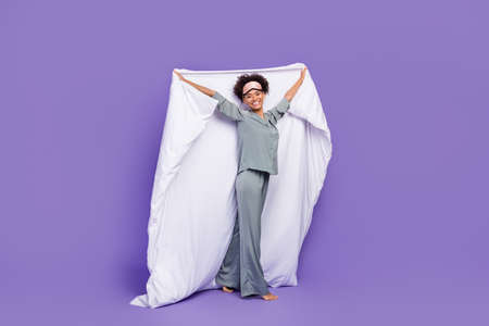 Photo shiny pretty african lady grey nightwear smiling rising blanket isolated purple color...