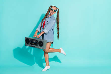 Photo of adorable beautiful young lady wear jeans shirt dark eyewear smiling dancing boombox empty...