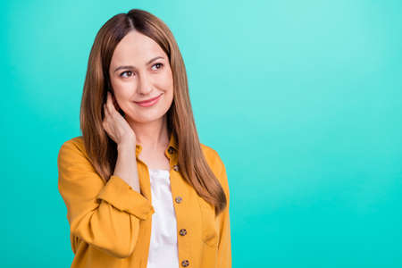 Photo of pretty dreamy mature lady wear yellow shirt hand arm neck looking empty space smiling...