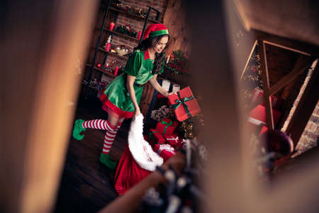 Full length profile photo of nice young brunette lady hold present wear green costume at home on holidayの写真素材