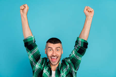 Photo of young amazed shocked man raise hands good mood winner isolated on pastel blue color backgroundの写真素材