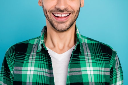Cropped photo of cheerful beaming smile young man clinic stomatology teeth whitening isolated on blue color backgroundの写真素材