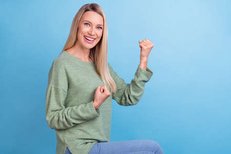 Profile side photo of mature excited woman good mood win lottery fists hands isolated over blue...