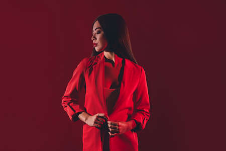 Portrait of gorgeous dreamy brunette girl posing nightclub party isolated over bright red light shine color backgroundの写真素材