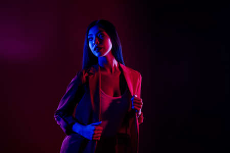 Portrait of gorgeous woman posing night club disco event isolated over dark red light shine color backgroundの写真素材
