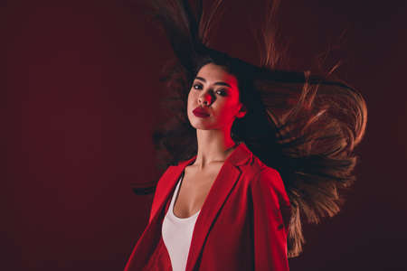 Photo of fancy young brunette lady wear red suit isolated on dark color backgroundの写真素材