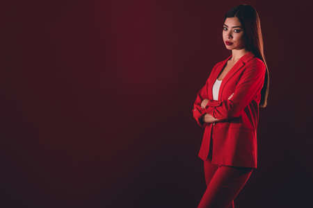 Photo of strict manager millennial brunette lady croosed arms wear red suit isolated on dark color backgroundの写真素材