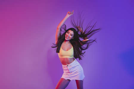 Portrait of attractive cheerful dreamy girl dancing rest relax isolated over vivid violet purple neon color backgroundの写真素材