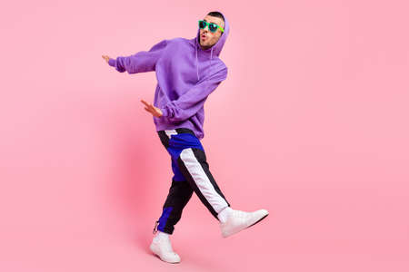 Full size photo of crazy millennial brunet guy dance wear eyewear hoodie pants shoes isolated on pink backgroundの写真素材