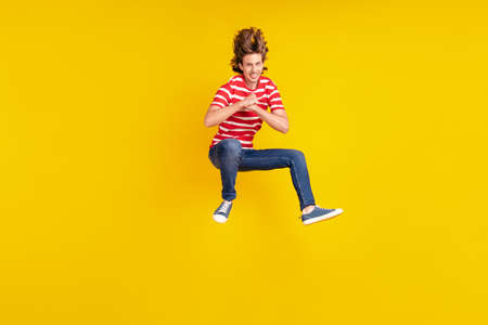 Full length body size view of attractive cheerful guy jumping having fun good mood isolated over...