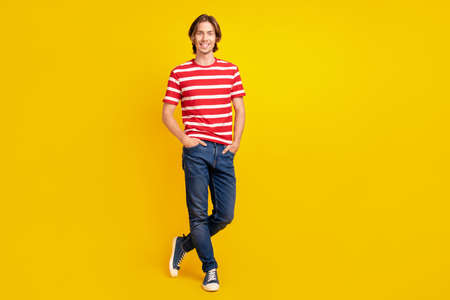 Full length body size view of attractive cheerful content guy posing crossed legs isolated over bright yellow color backgroundの写真素材