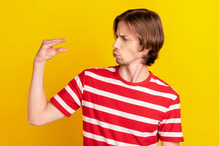 Photo of irritated annoyed young man wear striped t-shirt showing blah-blah-blah gesture isolated yellow color backgroundの写真素材