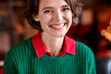 Photo of pretty shiny young lady wear green pullover smiling indoors house home roomの写真素材