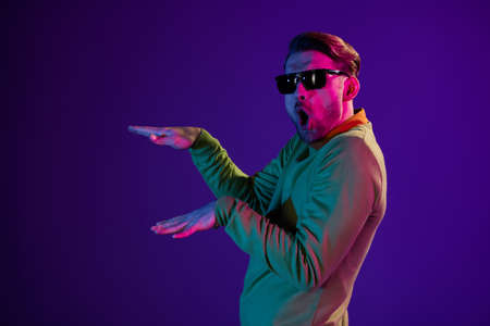 Photo portrait of man overjoyed wearing sunglass dancing in nightclub isolated on purple color backgroundの写真素材