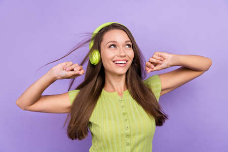 Photo of dreamy positive lady enjoy listen music headset wind blow hair look empty space isolated on...
