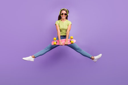 Full length body size view of lovely cheerful girl jumping listening pop having fun isolated over...