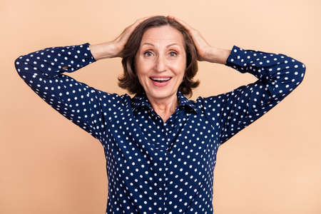 Photo of celebrate elder agent brunette lady hands face wear blue blouse isolated on beige color backgroundの写真素材